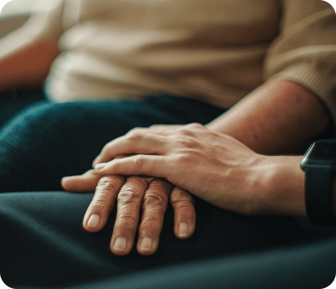 Hands touching in a comforting gesture.