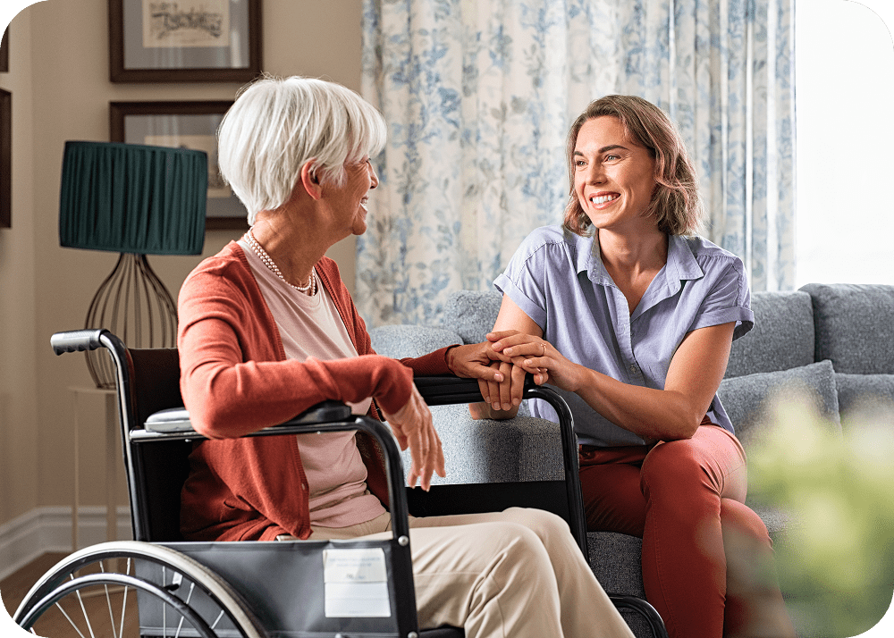 Elderly woman and caregiver sharing a conversation.